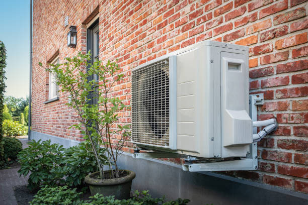 An air-conditioning unit mounted on a brick house wall